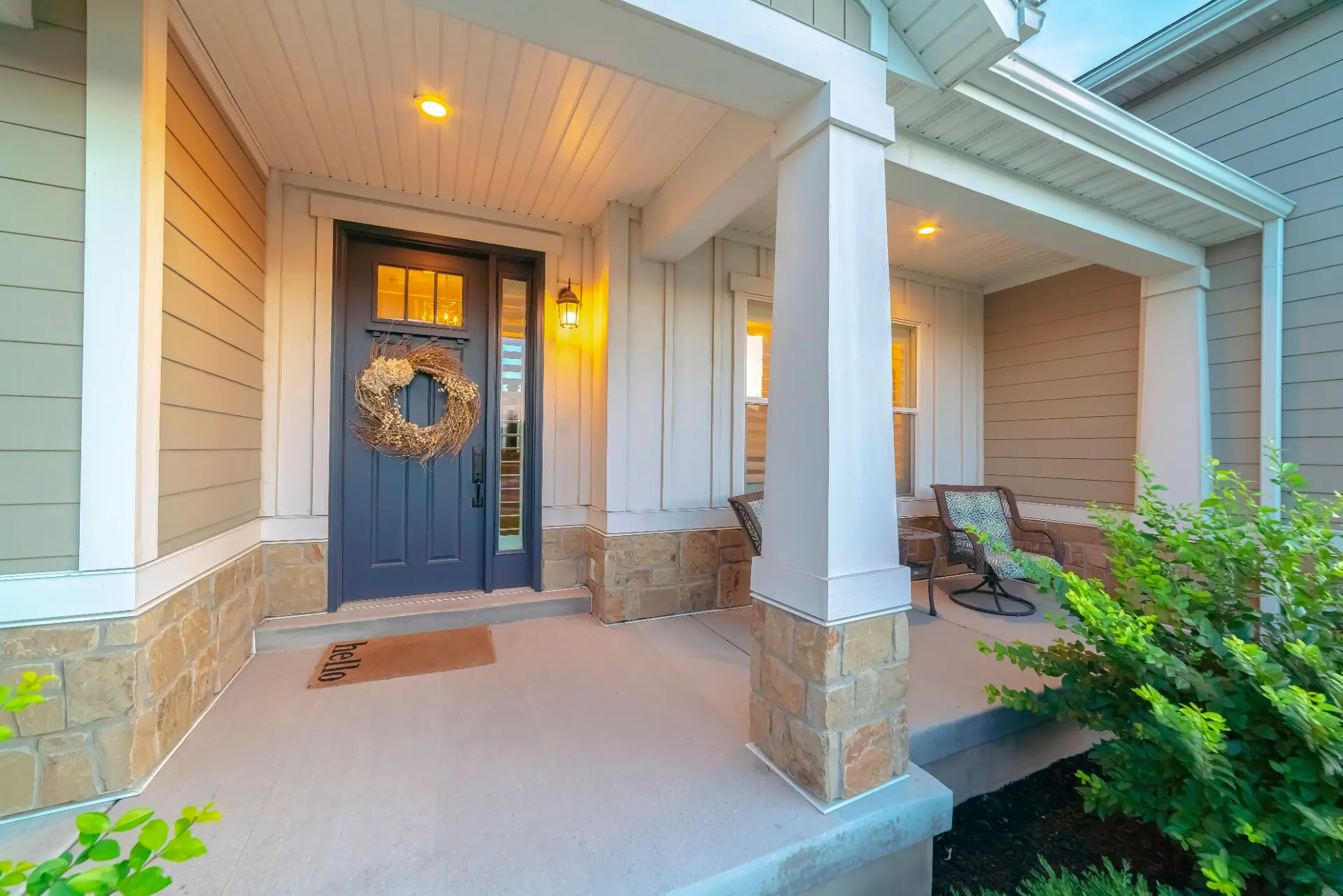Covered porch with stone bases, siding, soffit, and trim details